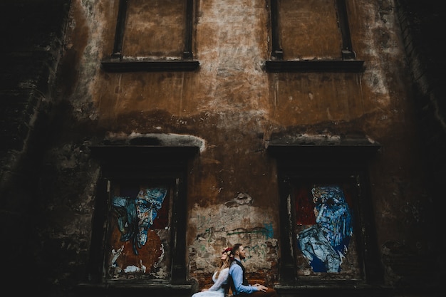 Foto grátis o lindo casal apaixonado sentado perto de prédio
