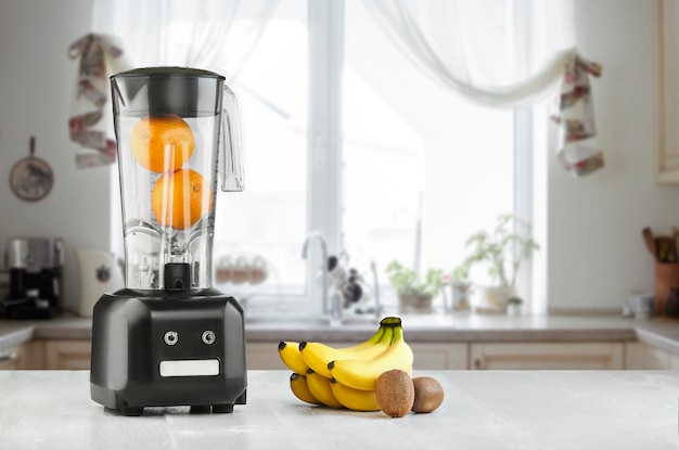 O liquidificador elétrico para fazer suco de frutas ou smoothie na mesa de cozinha de madeira. O conceito de uma dieta saudável.
