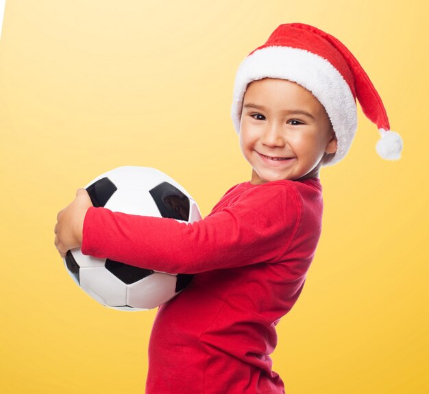 O menino ativo sorrindo com a bola