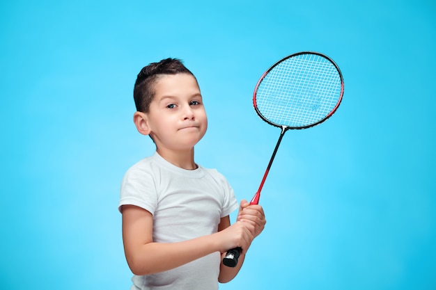 O menino com raquetes de badminton ao ar livre