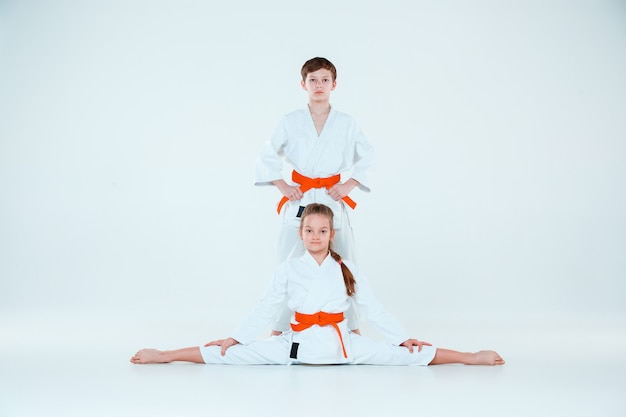 O menino e a menina posando no treinamento de Aikido na escola de artes marciais. Estilo de vida saudável e conceito de esportes