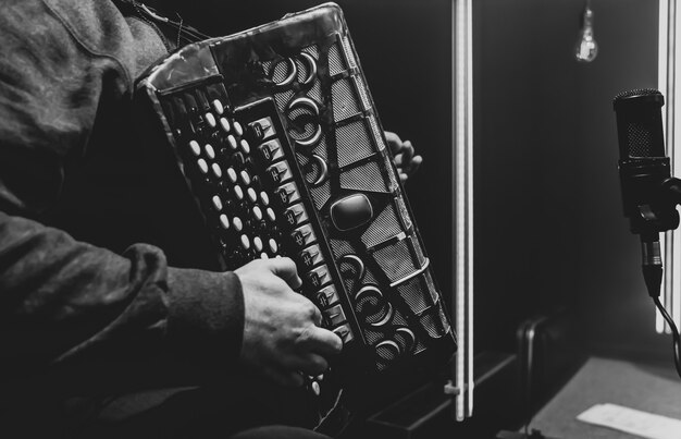 O músico toca o botão acordeão no estúdio