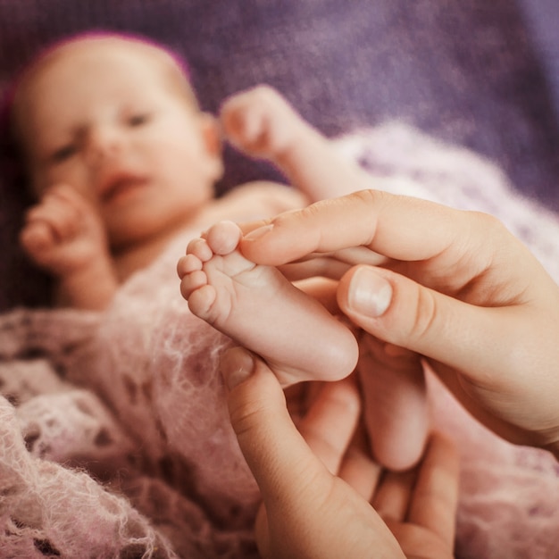 O pai toca os pés do bebê