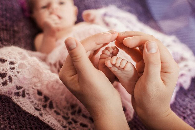 O pai toca os pés do bebê