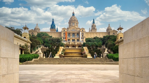 O Palau National em Barcelona, Espanha, jardins e as pessoas à sua frente. Céu nublado