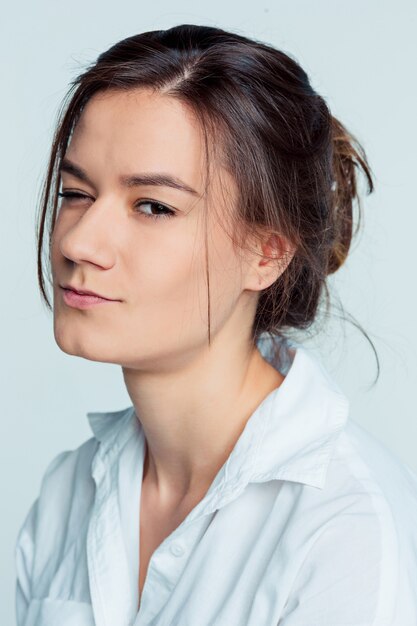 O retrato da jovem mulher com emoções pensativas no espaço azul