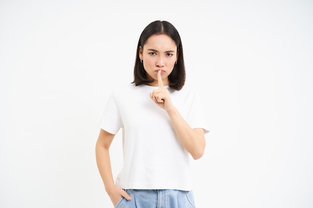 Foto grátis o retrato da menina shushes shhh gesto fala silenciosamente tabu para dizer algo diz que o segredo está acima