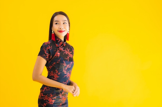 O retrato da mulher asiática nova bonita veste o vestido e sorrisos chineses
