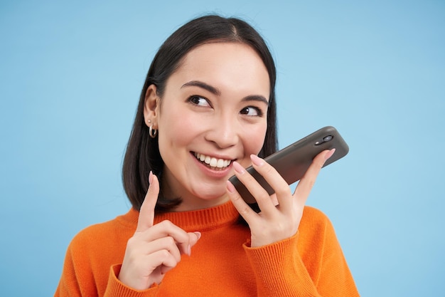 O retrato da mulher coreana grava a mensagem de voz no aplicativo do smartphone fala no alto-falante traduz seu spe