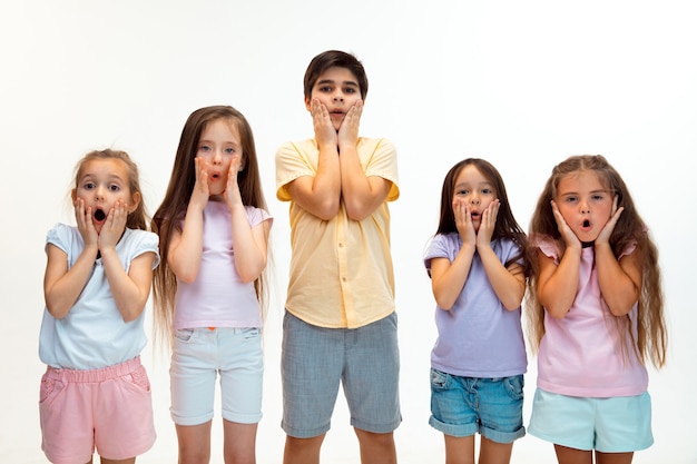 O retrato de felizes fofos crianças menino e meninas em elegantes roupas casuais. Moda infantil e conceito de emoções humanas