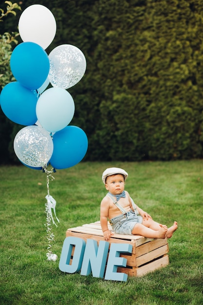 O retrato de um menino bonito com roupas elegantes faz aniversário hoje