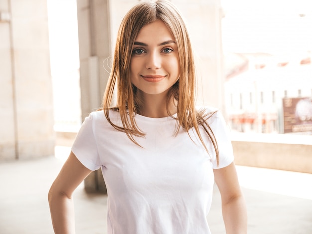 O retrato do modelo louro de sorriso bonito vestiu-se na roupa do moderno do verão.