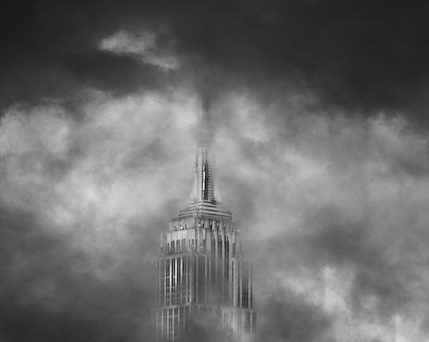 O topo de um arranha-céu cercado por nuvens