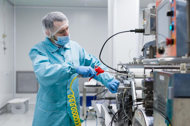 O trabalhador da fábrica da imagem da planta está consertando a fabricação de máquinas de aço da máquina