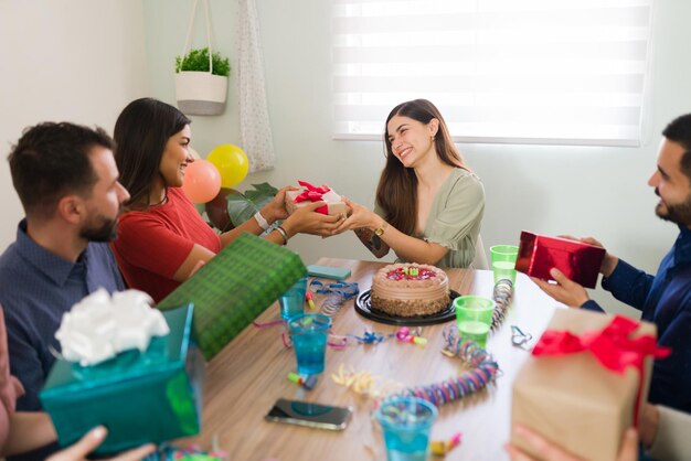 Obrigada! Melhor amigo dando a uma mulher feliz um lindo presente de aniversário durante uma festa divertida em casa com confete e bolo