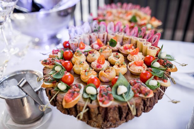 Óculos com martini e pratos de madeira com aperitivos em uma mesa de jantar