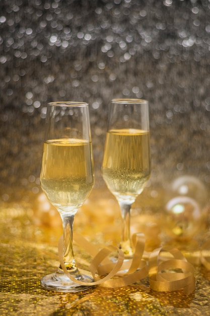 Foto grátis Óculos de vista frontal com champanhe na mesa