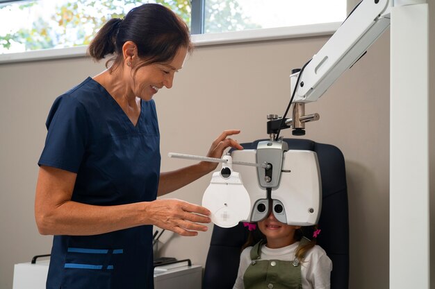 Foto grátis oftalmologia feminina dando a uma jovem um exame oftalmológico no escritório