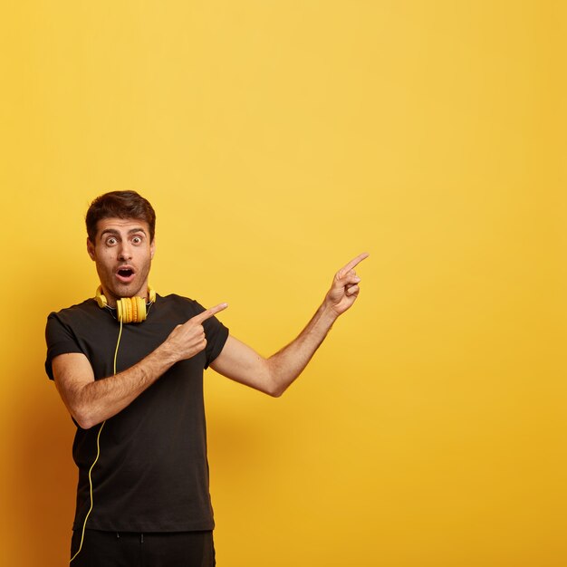 Oh não, olhe certo! Jovem assustado aponta para o espaço livre