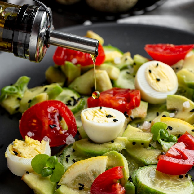 Foto grátis Óleo na salada fresca em close-up de tigela escura