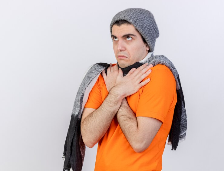 Foto grátis olhando para o jovem doente com chapéu de inverno e lenço cruzando e colocando a mão no ombro