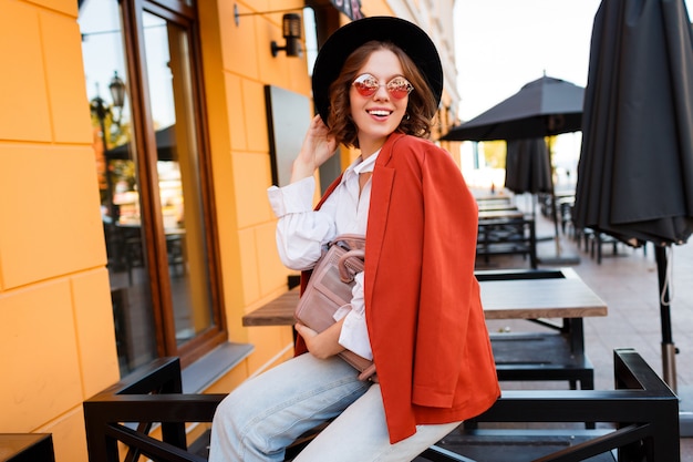 Olhar de moda de rua. incrível elegante garota viajando em roupa de outono na moda posando ao ar livre