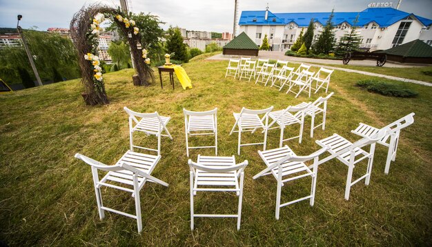 Olhe de cima em cadeiras brancas em pé ao redor do altar do casamento