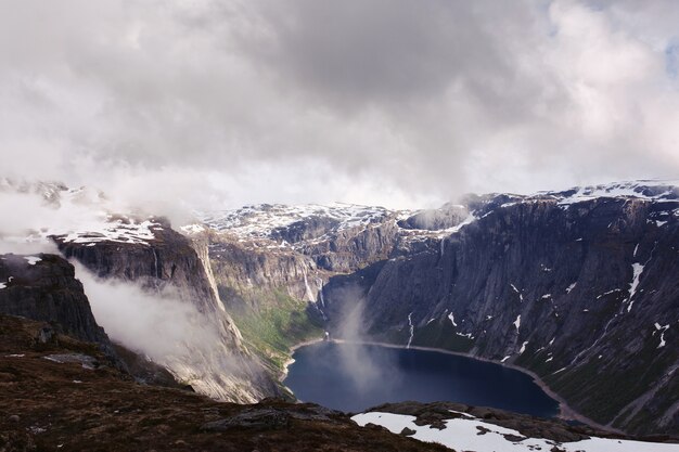 Olhe de cima no lago azul entre pedras altas na Noruega