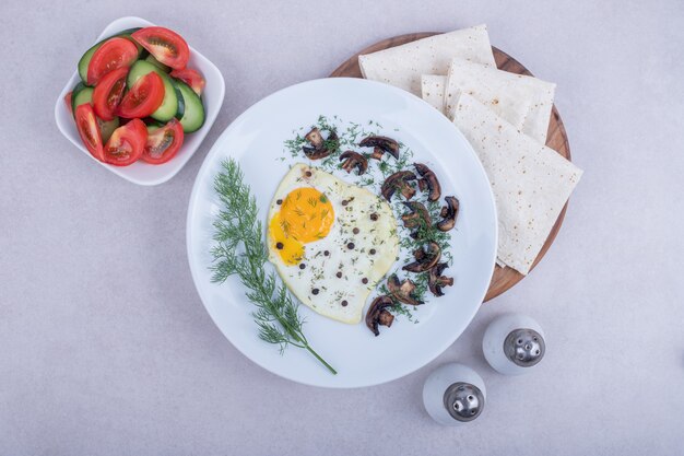 Omelete com pimenta e prato de tomate e pepino.