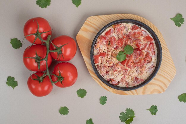 Omelete delicioso com tomate na placa de madeira.