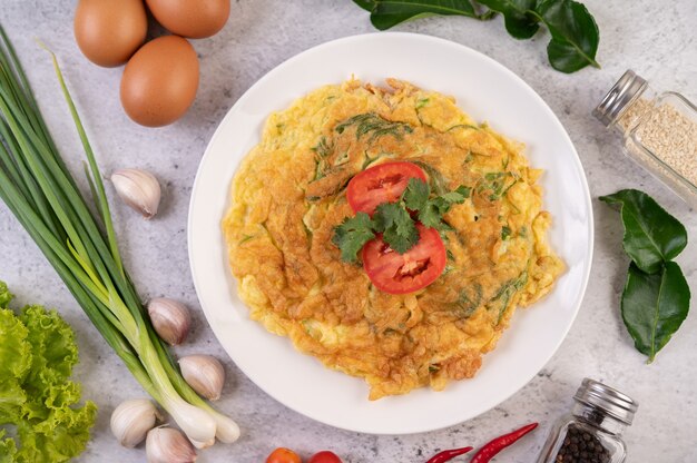 Omelete em um prato branco decorado com tomate e coentro.