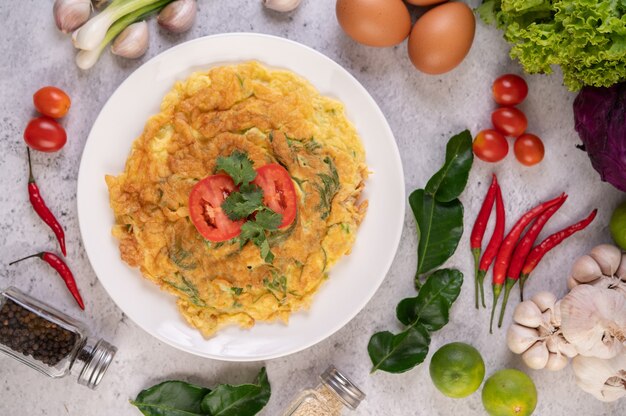 Omelete em um prato branco decorado com tomate e coentro.