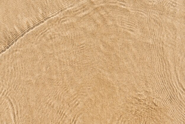 Onda suave do oceano azul na praia de areia. Fundo. Foco seletivo.