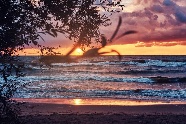 Ondas do mar, céu nublado incrível, belo pôr do sol. Vista do mar à noite