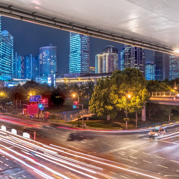 Opinião da cidade na noite com luz do tráfego e da fuga.