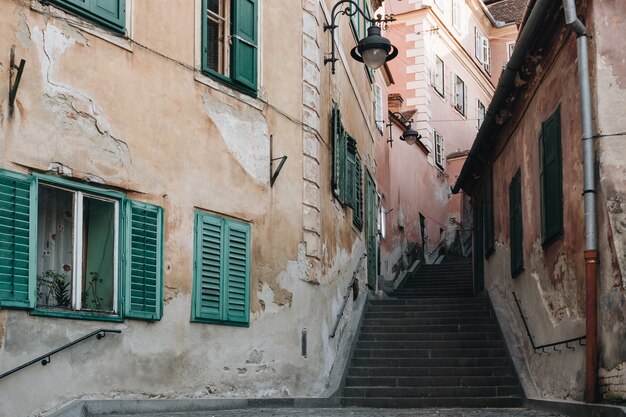 Opinião da rua da escada de Sibiu entre casas históricas velhas.