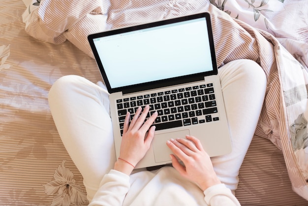 Opinião superior a mulher com laptop na cama