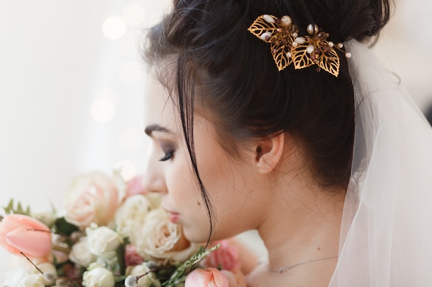 Foto grátis opinião traseira a noiva moreno nova com o barrete no cabelo. buquê de flores no fundo