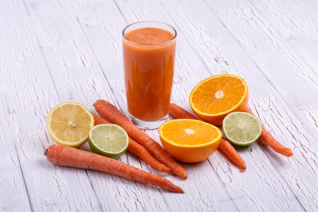 Foto grátis orange detox coctail com laranjas e cenouras fica na mesa branca