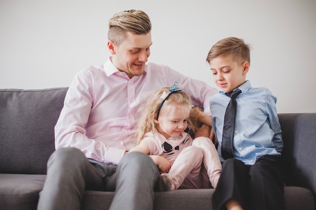 Foto grátis orgulhoso pai jovem com filho e filha