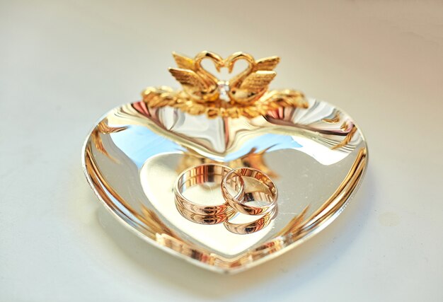 Os anéis de casamento encontram-se na linda placa dourada decorada
