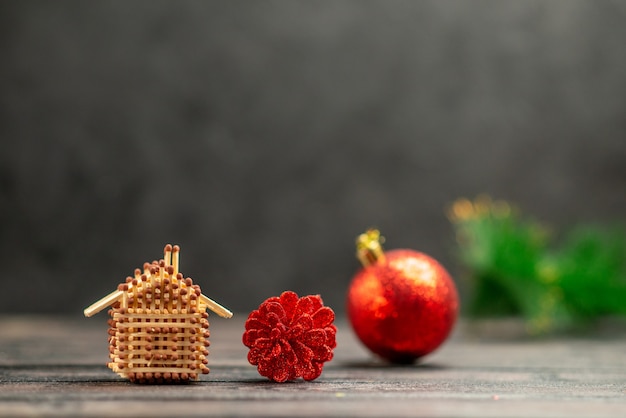 Os brinquedos da árvore de natal combinam com a casa no escuro espaço livre