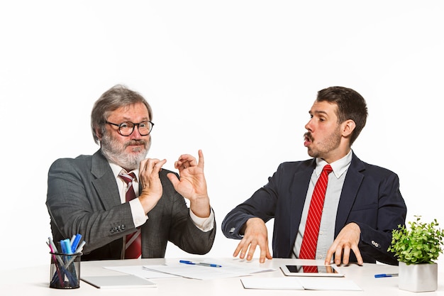 Os dois colegas trabalhando juntos no escritório em branco.