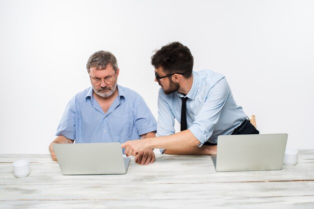 Os dois colegas trabalhando juntos no escritório em fundo branco