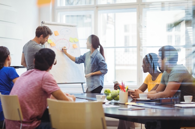 Os executivos de negócios discutir com os seus colegas sobre whiteboa