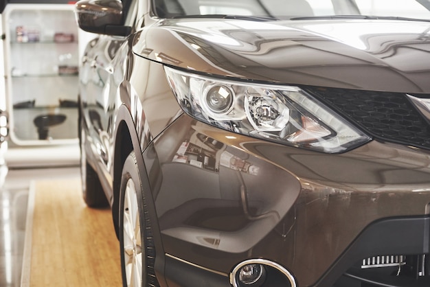 Os faróis e o capô de um carro preto de luxo.