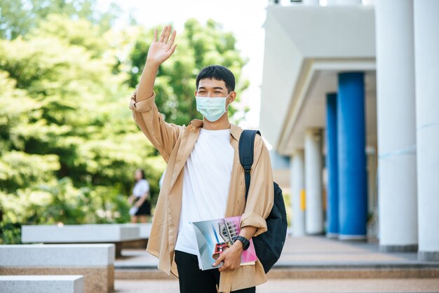 Os homens usam máscaras, carregam livros e carregam uma mochila nas escadas.