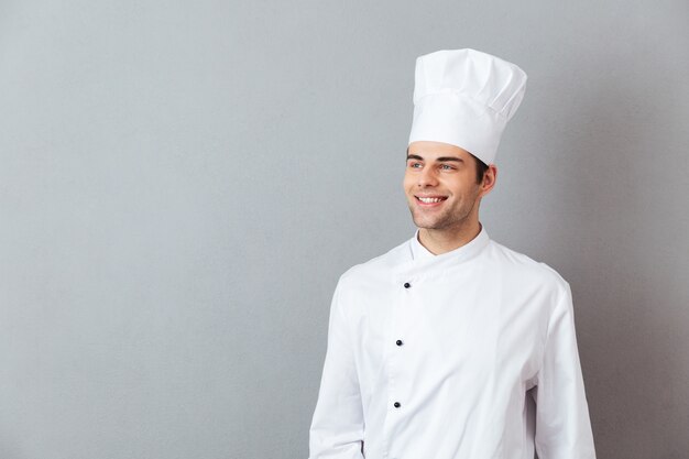 Os jovens cozinham em pé uniforme isolado