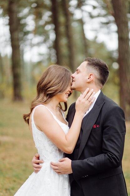 Os noivos correm por uma floresta Sessão de fotos de casamento