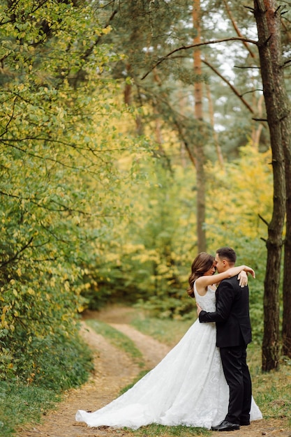 Os noivos correm por uma floresta Sessão de fotos de casamento